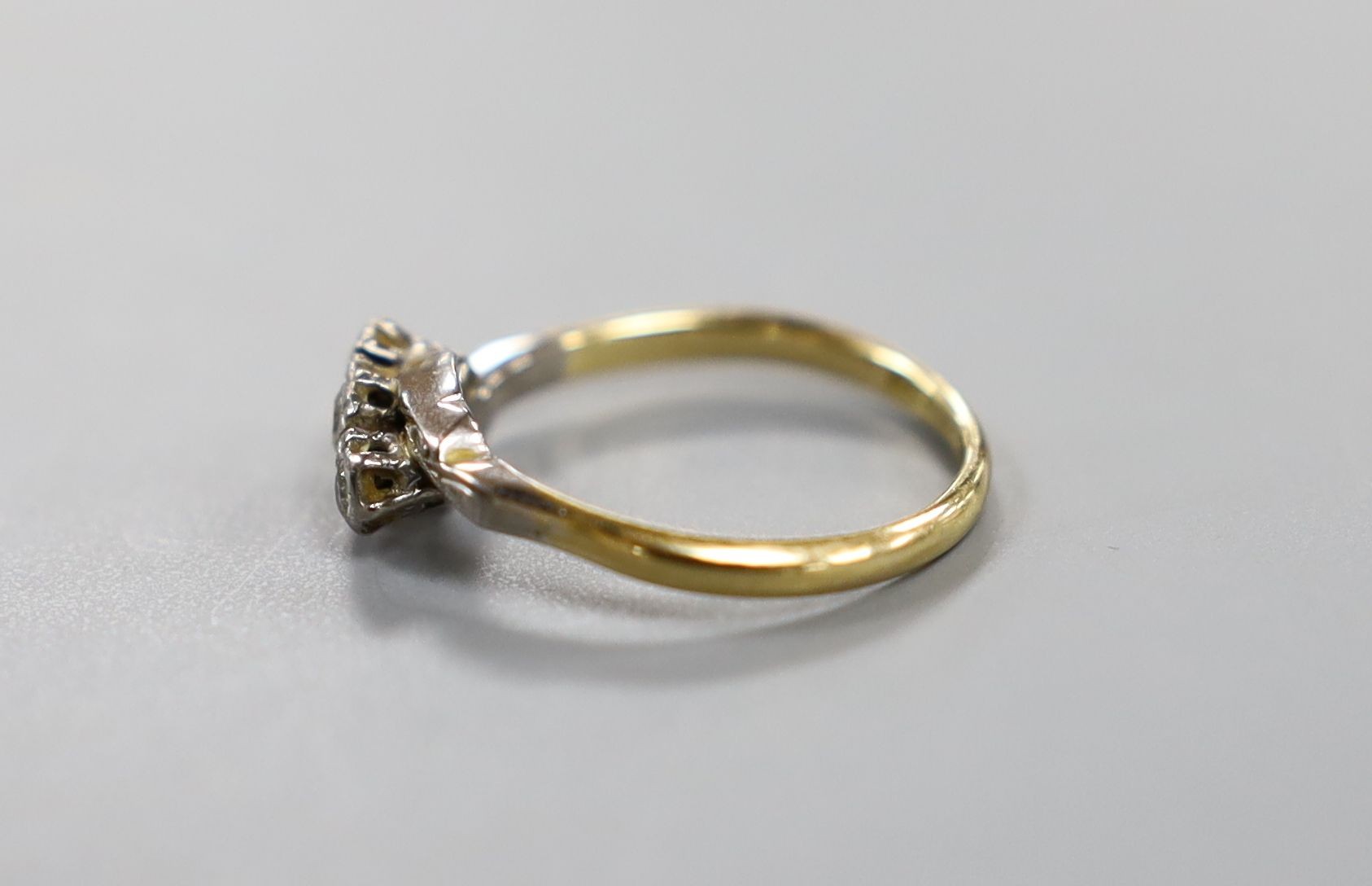 An 18ct, plat and three stone diamond crossover ring, size O, gross 2.4 grams.